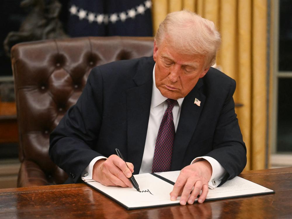 President Trump signs an executive order in the Oval Office of the White House in Washington, D.C., on Jan. 20.