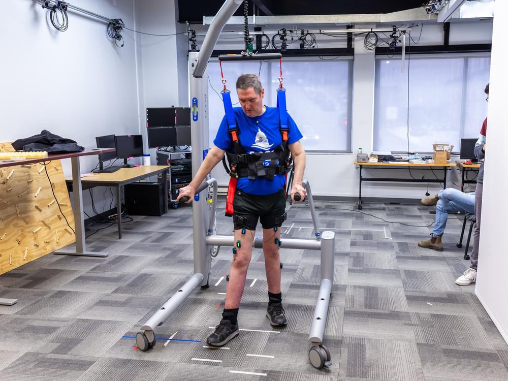 Research participant Doug McCullough uses the bodyweight support system to walk during a testing session at the University of Pittsburgh.