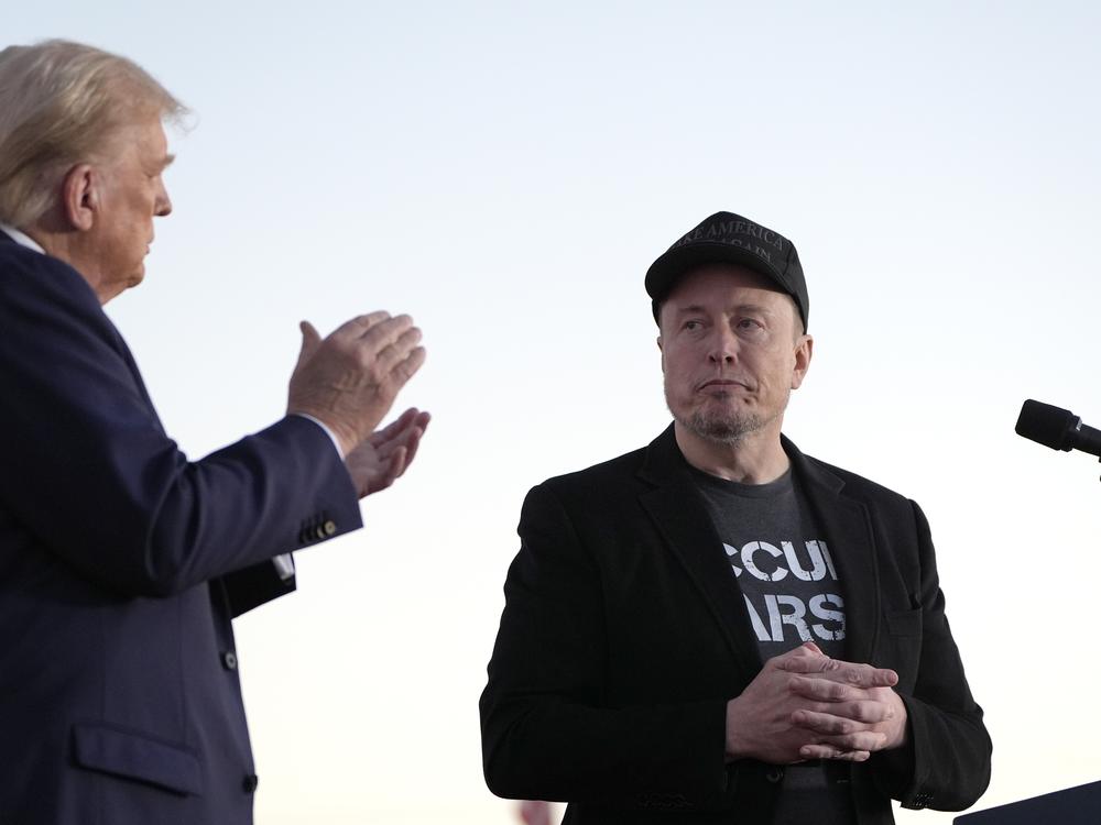 Republican presidential nominee former President Donald Trump, left, claps as Tesla and SpaceX CEO Elon Musk prepares to depart after speaking at a campaign event at the Butler Farm Show, on Oct. 5, 2024, in Butler, Pa.
