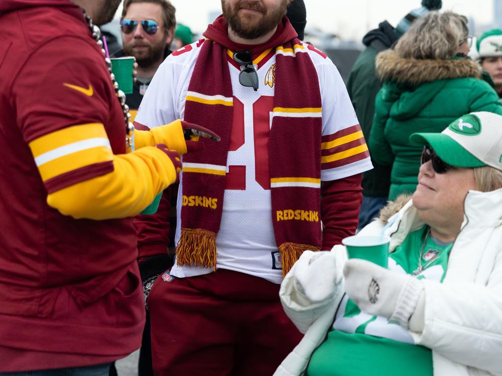 Washington Commanders fan Eddie Jenkins (center) chats with Philadelphia Eagles fans. 