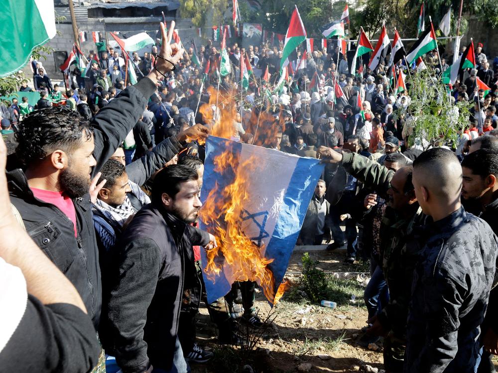 Palestinian refugees burn an Israeli flag during a demonstration at the Jaramana Camp on the edge of Damascus, Syria, in 2017. At that time, they were protesting President Trump's decision to move the U.S. Embassy in Israel from Tel Aviv to Jerusalem. Today, they are opposed to Trump's call for Gaza residents to be relocated.