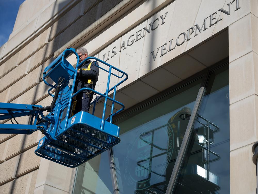 On February 7, a worker removes the U.S. Agency for International Development sign on their headquarters in Washington, D.C.  The Trump administration has targeted with agency with a series of orders that have put its programs and employees in limbo.