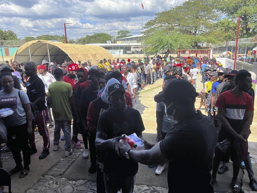 Haitians line up at a non-profit help center to receive food after being deported from the Dominican Republic, in Belladere, Haiti on Jan. 30.