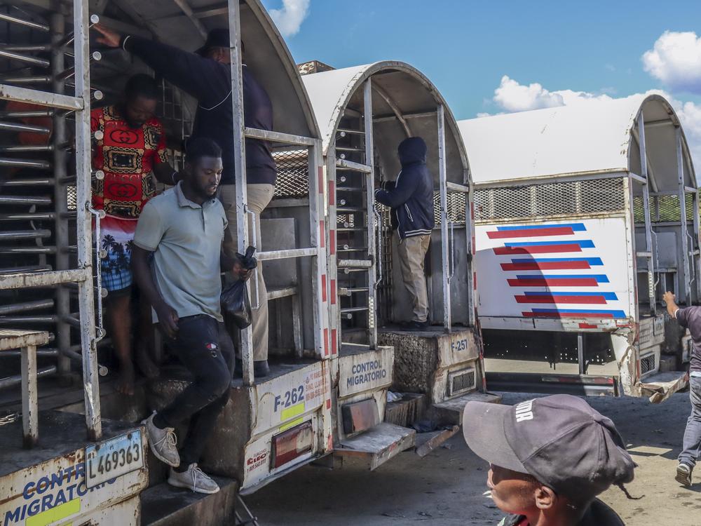 Haitians deported from the Dominican Republic get out of trucks in Carrizal, Dominican Republic, on the border with Haiti on Jan. 30.