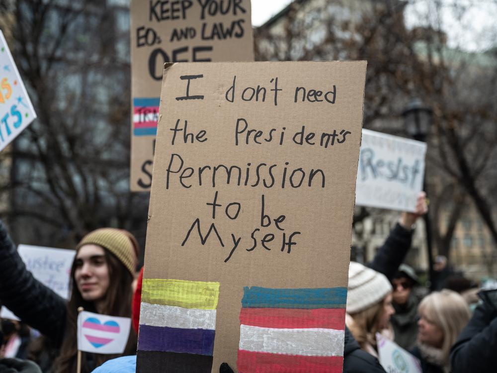 A homemade sign at a rally in Union Square in New York City on Saturday. Various hospitals across the country curbed gender-affirming care for people under 19 after President Trump's executive order.