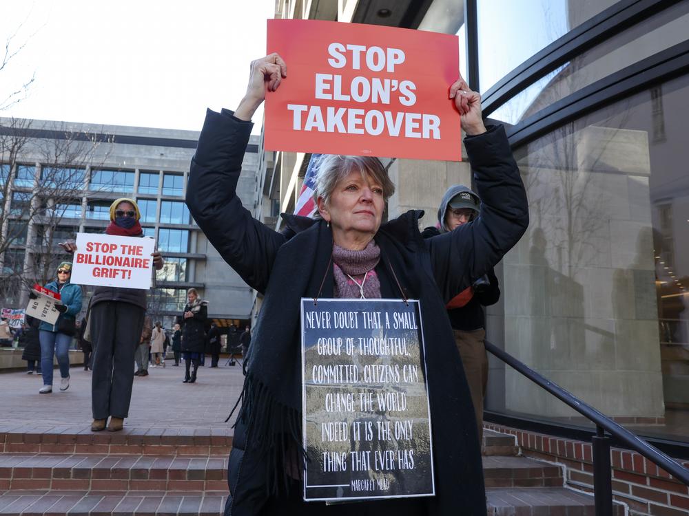 Demonstrators hold signs and posters at a rally to protest the closing of the Consumer Financial Protection Bureau, on Feb. 10 in Washington, D.C.