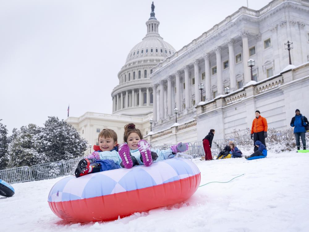 James Prince, 4, and Olivia Averyt, 4, sled down a hill at the Capitol, Wednesday, after a snowstorm in Washington.