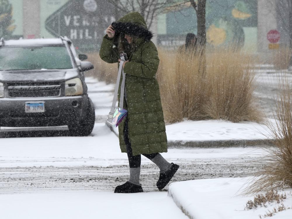Pedestrian crosses the street during a snowy day in Vernon Hills, Ill., Wednesday.