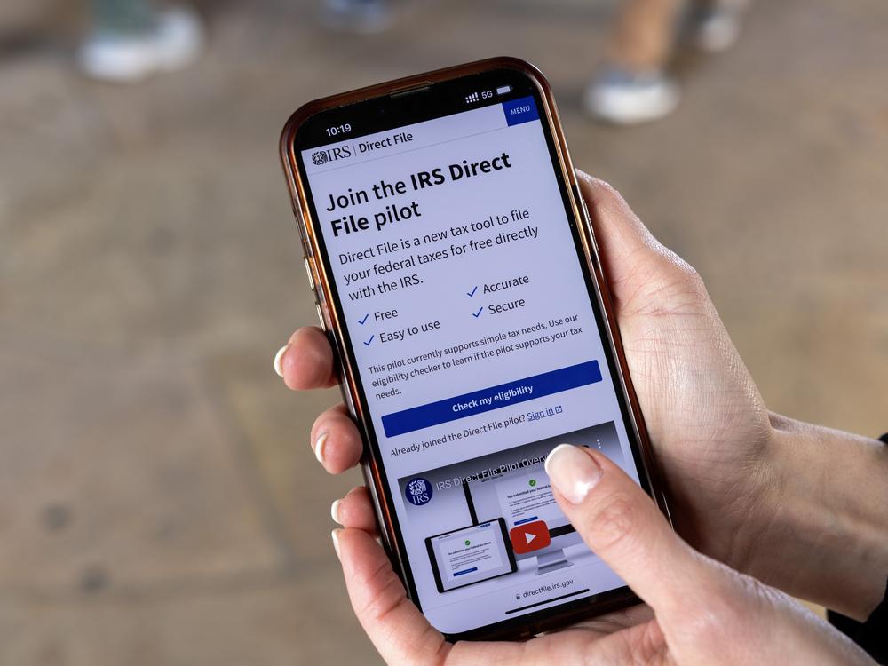 A phone user looks at information about the IRS Direct File program at the IRS building in Washington, D.C., last April. The free tax return service has now grown to 25 states.