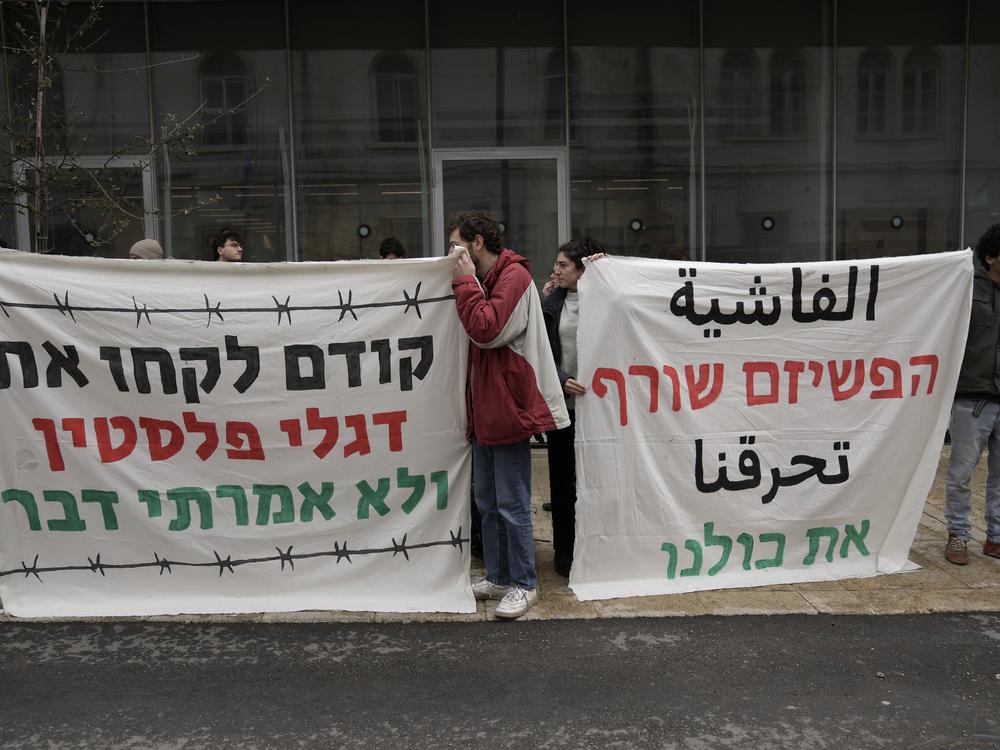 People protest after the Munas' arrest, in east Jerusalem, Feb. 10, 2025. A sign at left: 