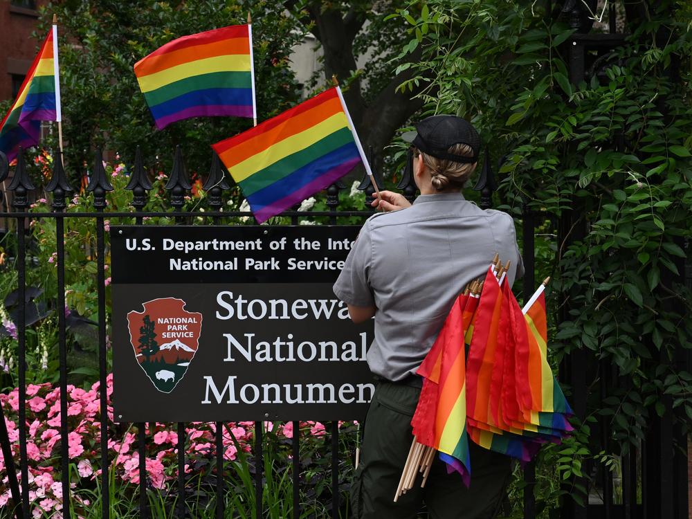 A National Park Service ranger places rainbow flags on the fence at the Stonewall National Monument in the West Village neighborhood of Greenwich Village in Lower Manhattan, New York City, on June 19, 2019.