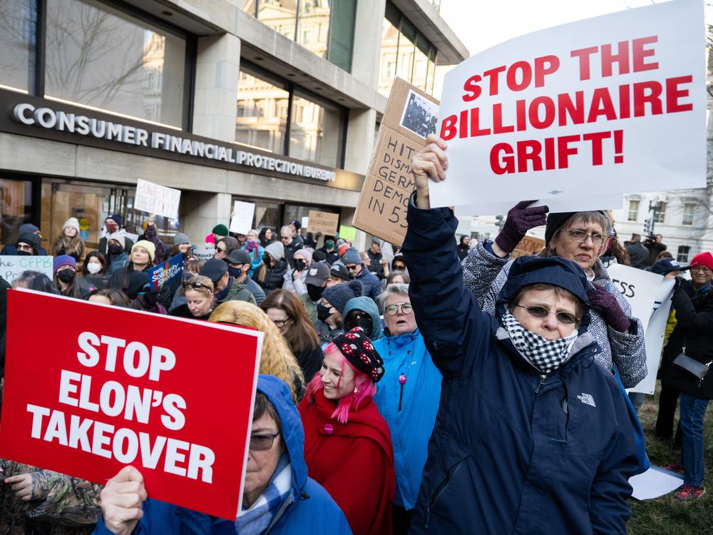Demonstrators hold signs in front of the agency's headquarters in Washington, D.C., on Feb. 10, 2025, as they protest against the Trump administration's plans to target the CFPB