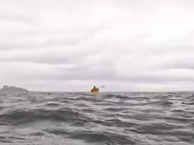 A screenshot of a video from the Associated Press shows Adrián Simancas kayaking in the Strait of Magellan, moments before a whale surfaced and briefly engulfed him.