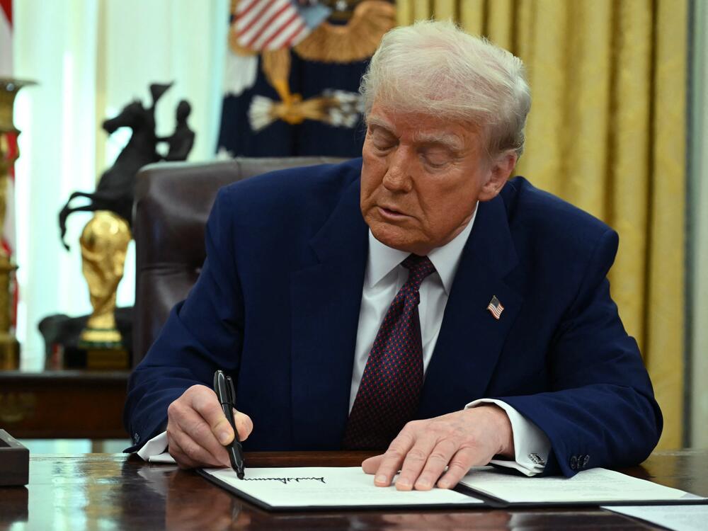 President Trump signs an executive action on tariffs in the Oval Office on Feb. 13, 2025.