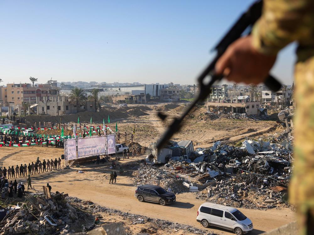 A Hamas militant keeps watch from a building over an area before handing over two Israeli hostages to a Red Cross team in Khan Yunis, southern Gaza Strip, on Feb. 15, 2025, as part of the hostage-prisoner exchange.