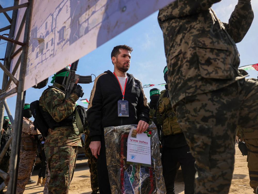 Hamas militants escort Israeli-American hostage Sagui Dekel-Chen on a stage before handing him over to a Red Cross team in Khan Yunis, southern Gaza Strip, on Feb. 15, 2025, as part of the sixth hostage-prisoner exchange.