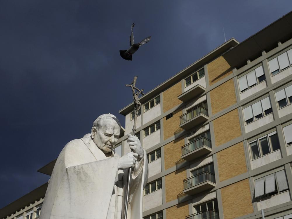 A marble statue of late Pope John Paul II is backdropped on Saturday by the Agostino Gemelli Polyclinic in Rome, where Pope Francis was hospitalized after a weeklong bout of bronchitis worsened.