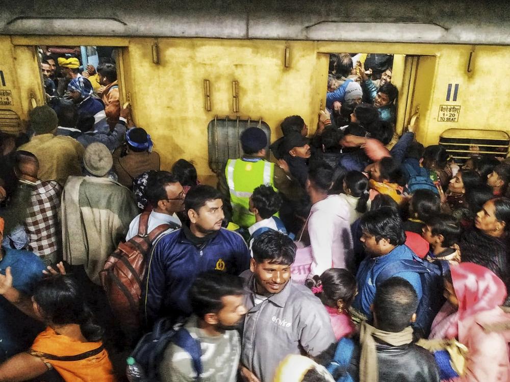 Passengers jostle with each other to board a train at the New Delhi Railway station, in New Delhi, India, Saturday, Feb.15, 2025.