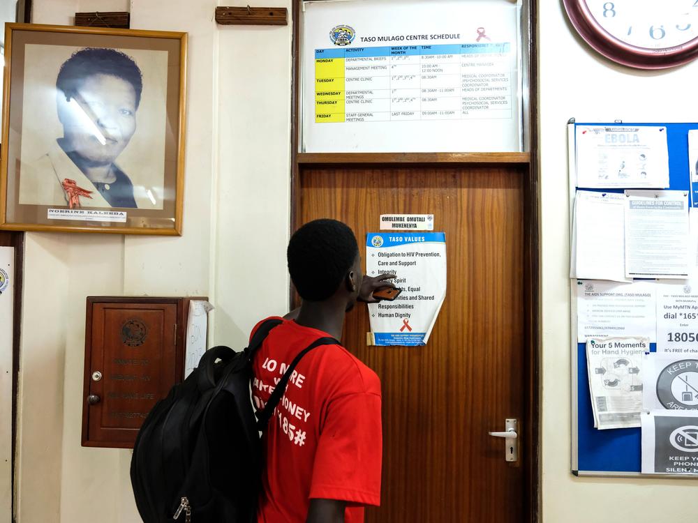 A man reads a poster in the office of The AIDS Support Organization in Kampala, Uganda. Half the group's funding is from the United States Agency for International Development (USAID). The Trump administration froze virtually all foreign aid funds for 90 days, then issued a waiver for life-saving activities. Now a judge has ordered a temporary halt to the freeze.