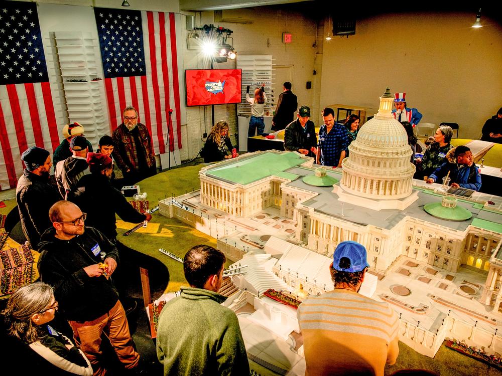The board — a green lawn and marble steps — surrounds a detailed, nearly 14-foot, plastic replica of the Capitol.