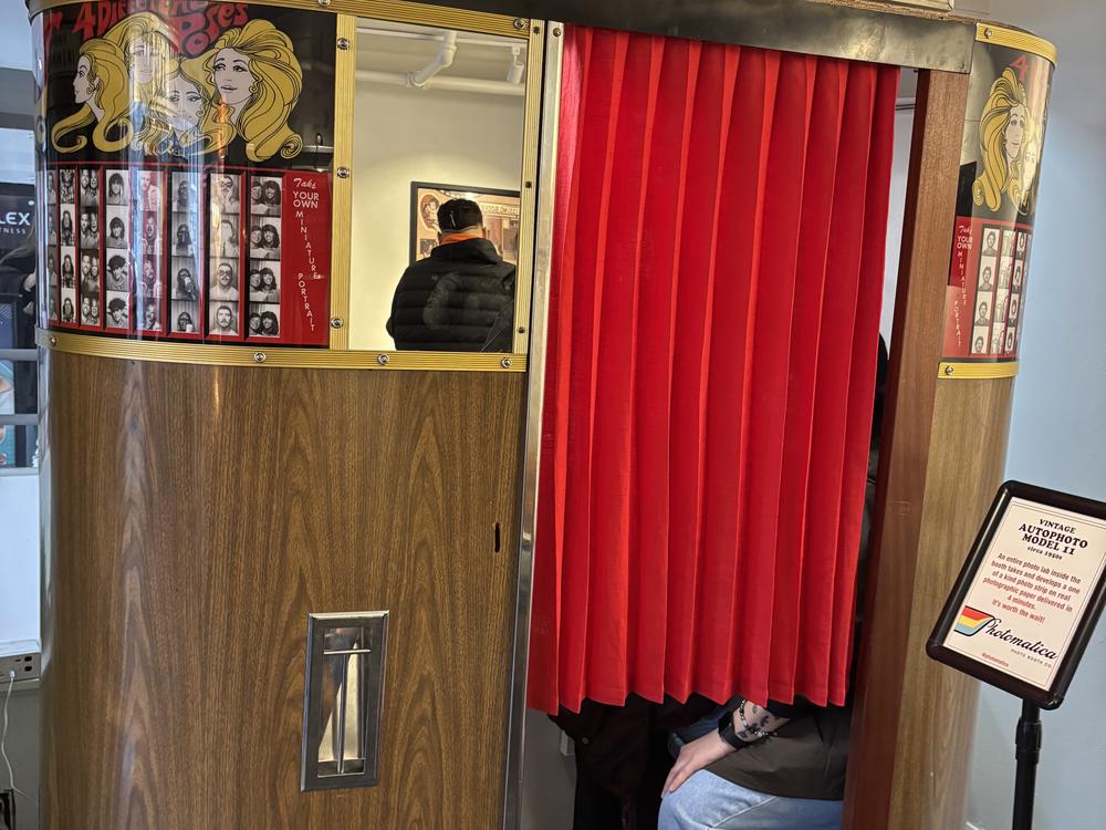 Guests get cozy in a vintage machine at the Photo Booth Museum by Photomatica in San Francisco.