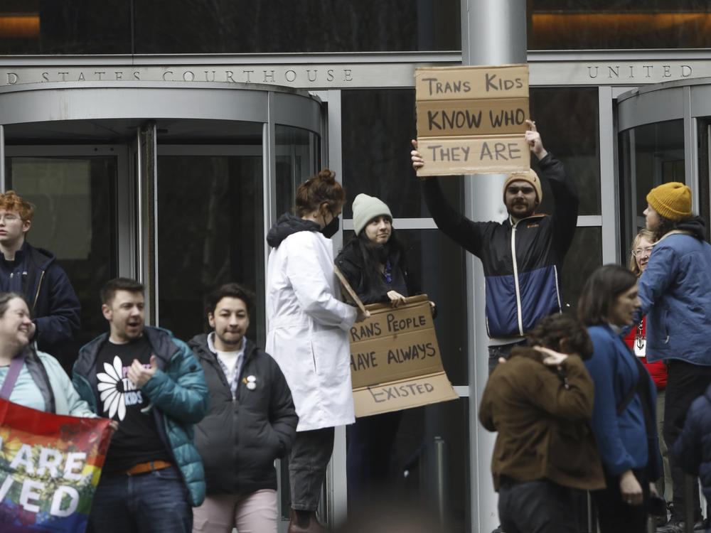 People celebrate outside a Seattle federal courthouse after a second federal judge paused President Trump's order against gender-affirming care for youth on Friday.