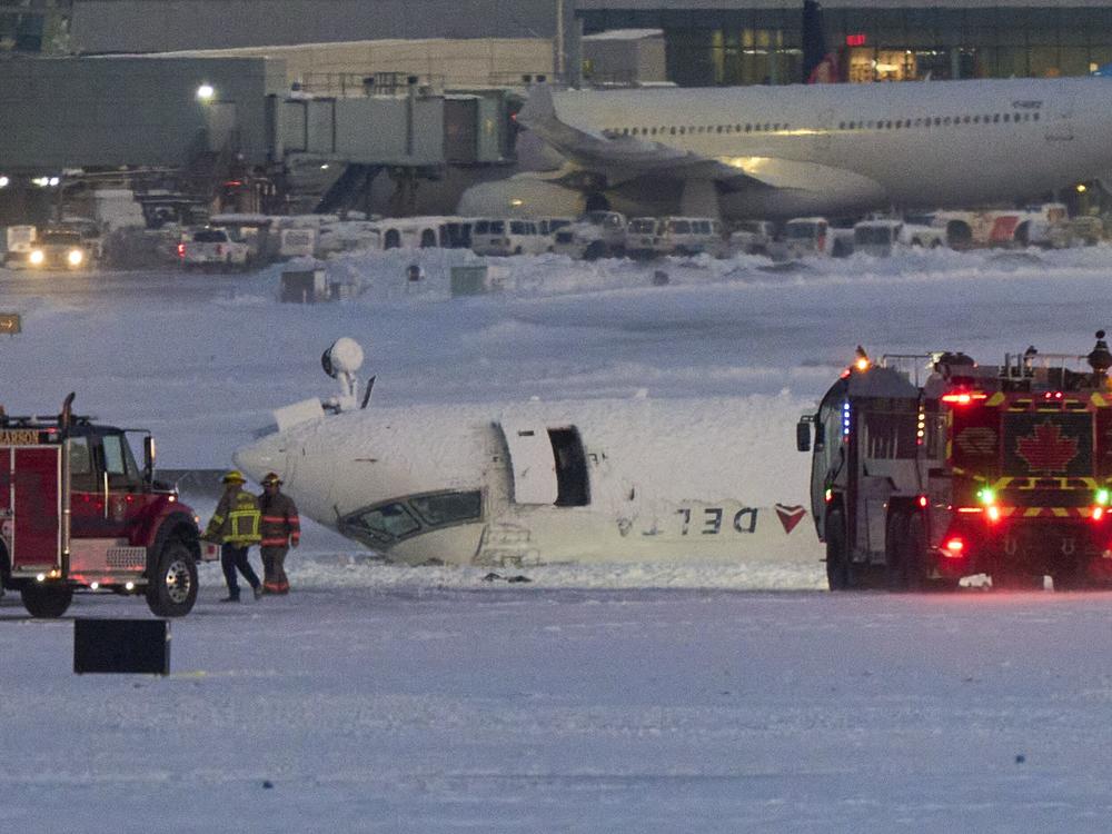A Delta Air Lines regional jet sits upside-down after crashing upon landing at Toronto Pearson International Airport on Monday.