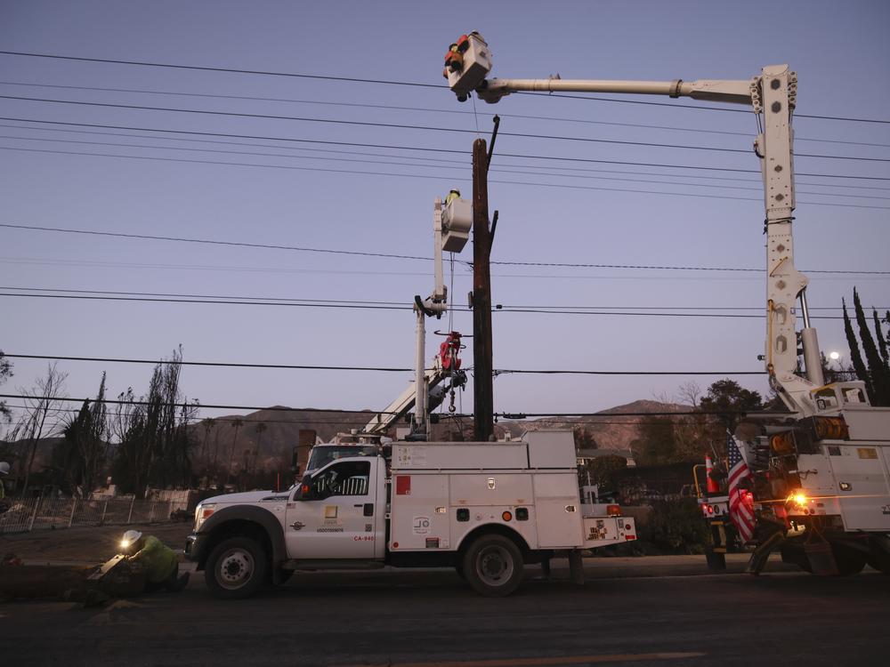 Southern California Edison workers service a utility pole in the aftermath of the Eaton Fire in Altadena on Jan. 12.