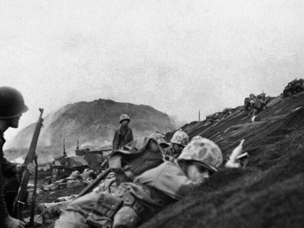 One of the first waves of Marines to hit the beach hug the ground as they land on Iwo Jima, on D-Day, Feb. 19, 1945.