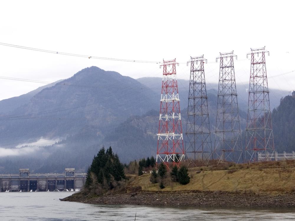 Power lines from Bonneville Dam head cross the Columbia River in North Bonneville, Wash. The Bonneville Power Administration is cutting several hundred jobs.