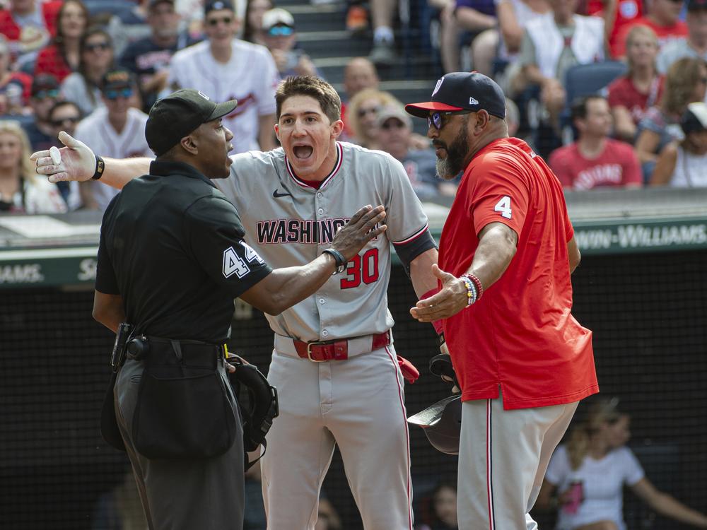 Washington Nationals' Jacob Young (30) argues a called third strike with umpire Malachi Moore, left, as Nationals manager Dave Martinez, right, joins in during the third inning of a baseball game against the Cleveland Guardians in Cleveland on June 1, 2024.