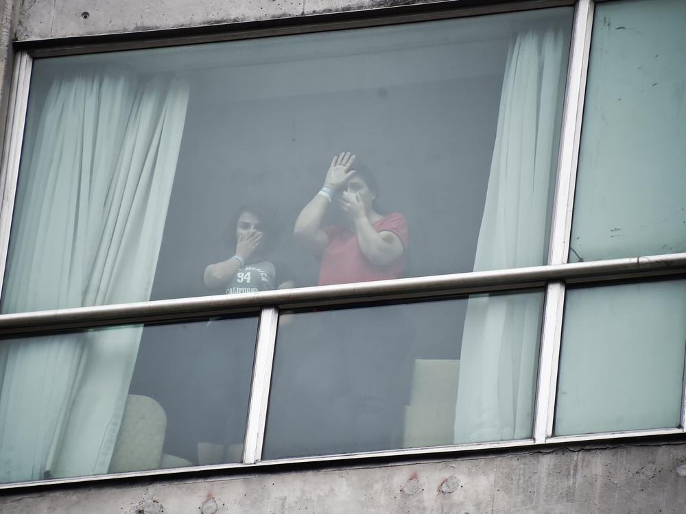 Migrants deported from the United States wave to the press from inside a hotel in Panama City on Wednesday.