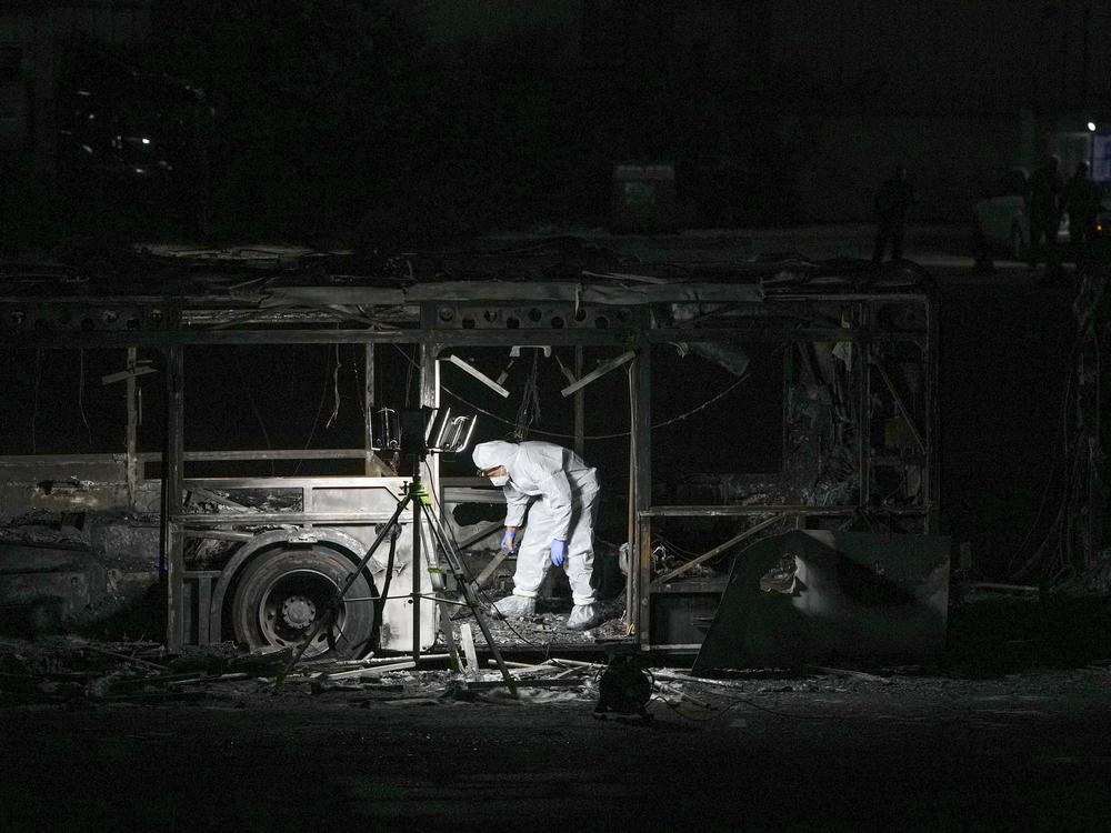An Israeli police officer inspects the scene of one of a series of bus explosions in what authorities said appeared to be a militant attack in Bat Yam, central Israel on Feb. 20, 2025.