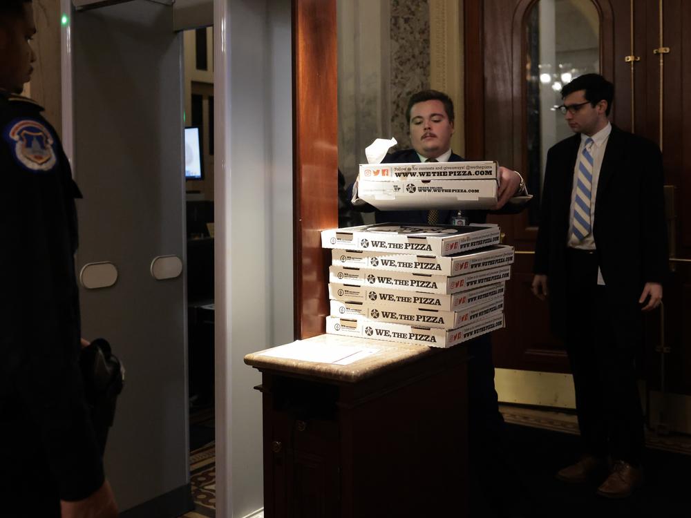 Workers bring boxes of pizza into the U.S. Capitol ahead of a Senate 