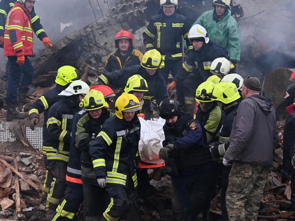 Ukrainian firefighters carry the body of a civilian following a missile strike in the eastern town of Poltava on Feb. 1. Russia carries out daily airstrikes that often hit civilians.