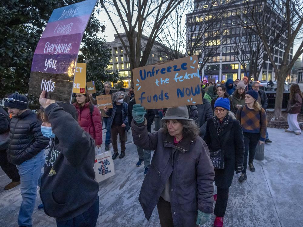 People protest near the White House in Washington on Jan. 28. against a funding freeze of federal grants and loans following a push from President Trump to pause federal funding.
