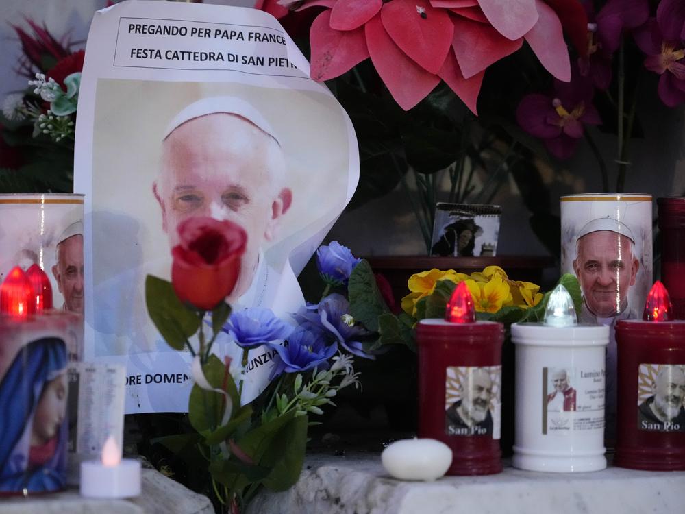 Candles are seen near pictures of Pope Francis outside the Agostino Gemelli Polyclinic in Rome, on Sunday, where the Pontiff is hospitalized since Feb. 14.