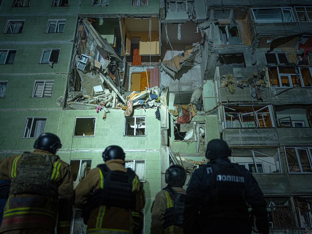 A rescue team gathers in front of a damaged residential building in Sumy just after a Russian drone strike that destroyed nine apartments and killed 11 people, Jan. 30.