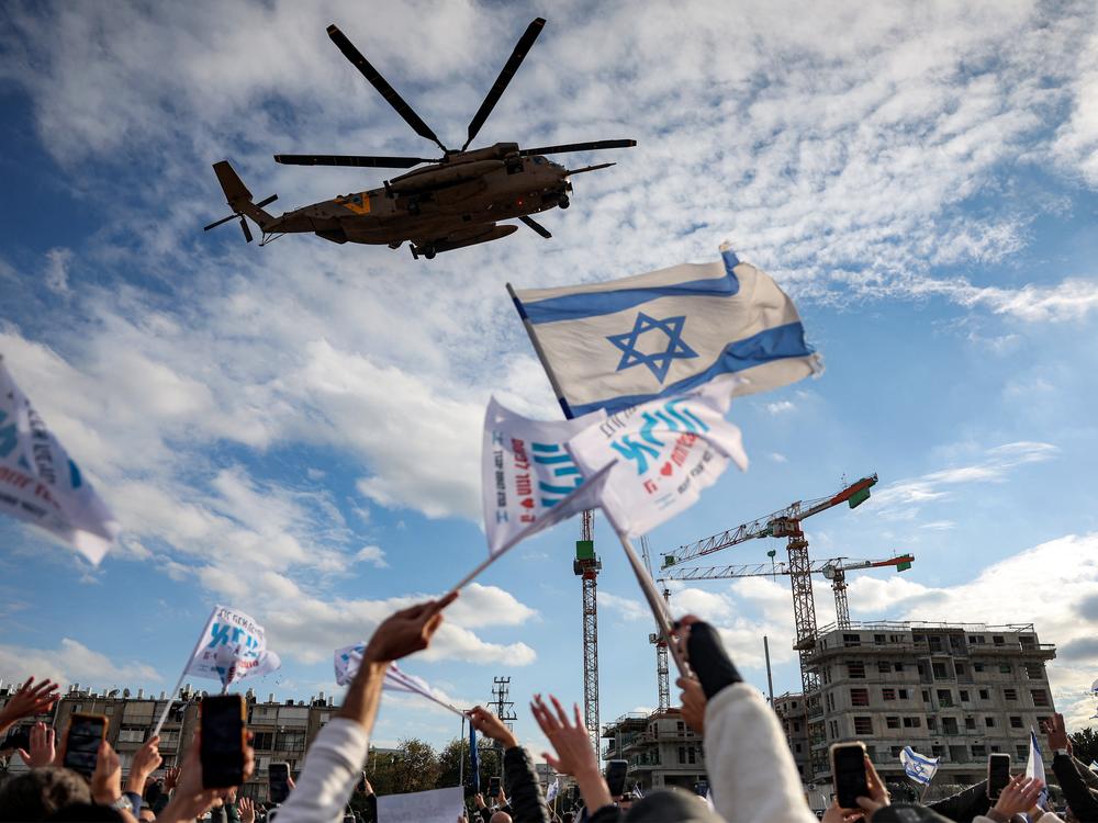 People cheer as an Israeli Air Force CH-53 military transport helicopter carrying newly-released Israeli hostages Omer Shem Tov and Eliya Cohen arrives at Beilinson Hospital in the Rabin Medical Centre in Petah Tikva in central Israel on February 22, 2025.