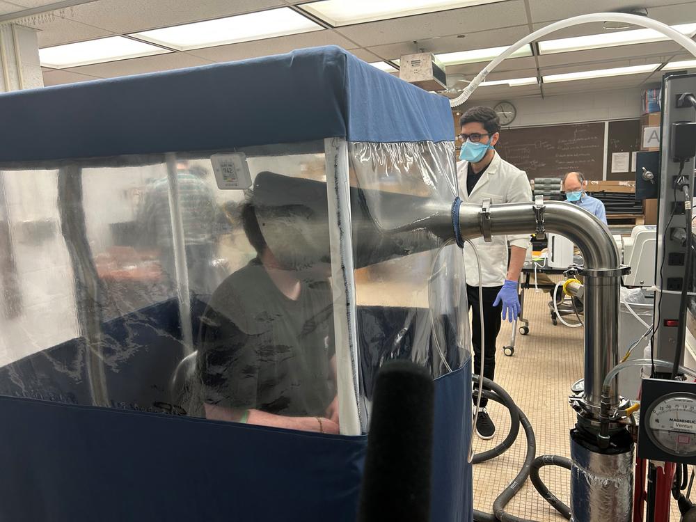 A person breathes inside the Gesundheit II, a machine that allows scientists to study the behavior of pathogens when they're exhaled. Research like this is at risk amid the Trump administration's proposed funding cuts.