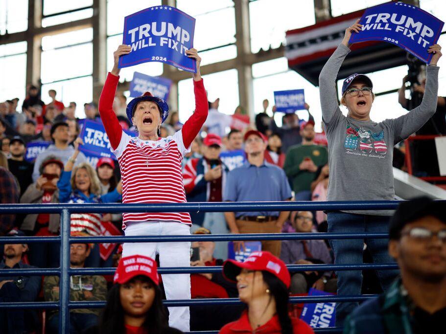 People hold up signs before Republican presidential nominee, former U.S. President Donald Trump holds a campaign rally Nov. 4, 2024 in Raleigh, North Carolina.