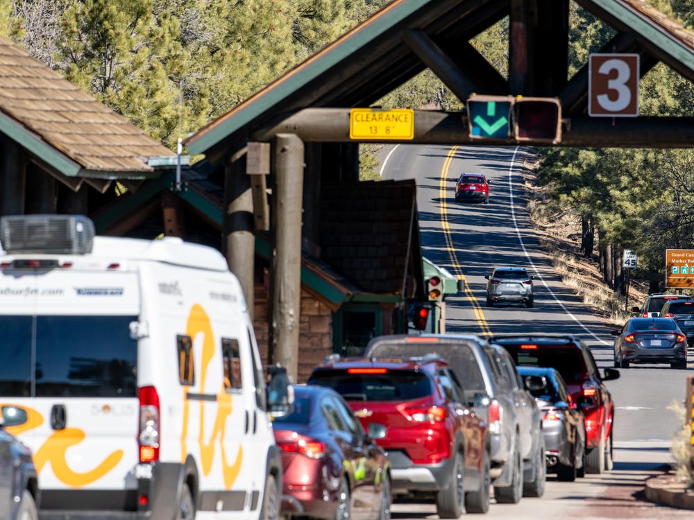 Vehicles wait in line at an entrance to the Grand Canyon National Park on Sunday. It's not clear how many park staff lost their jobs, but Arizona's governor has expressed concern about the economic impact of the layoffs.
