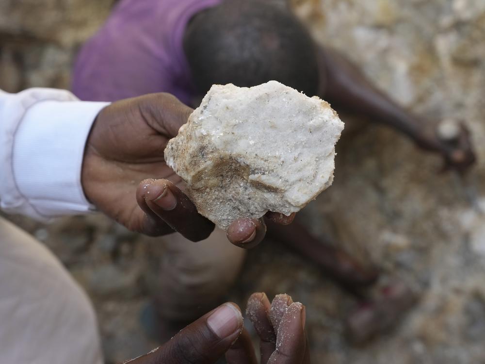 A man shows lithium stone from an illegal mining site in Paseli, north central Nigeria, Tuesday, Nov 5, 2024.