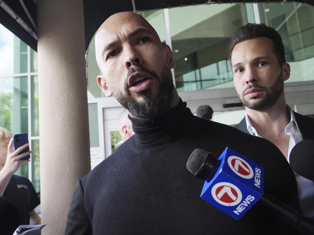 Andrew Tate (foreground) and his brother Tristan arrive in Fort Lauderdale, Fla., on Thursday, after Romanian authorities lifted travel restrictions against them.