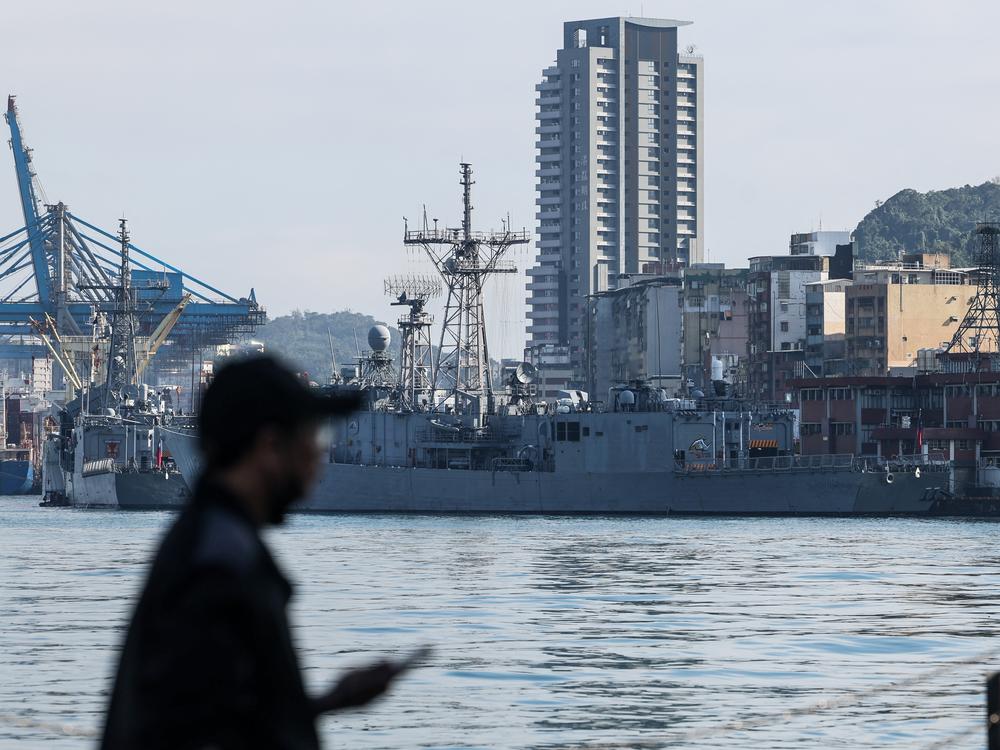 A man stands in front of Taiwanese navy ships anchored at the harbor in Keelung, near Taipei in northern Taiwan, on Dec. 11, 2024.