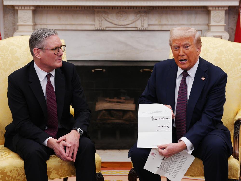 British Prime Minister Keir Starmer hands an invitation from King Charles III for a second state visit to President Trump at the White House on Thursday.