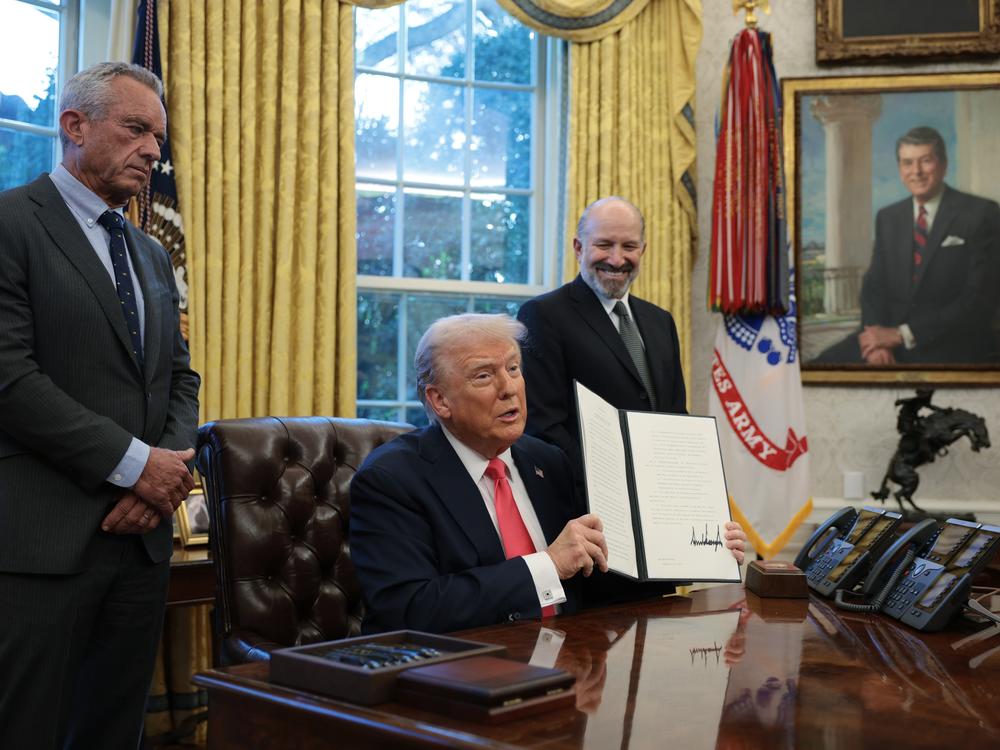 President Trump, joined by Health and Human Services Secretary Robert F. Kennedy Jr. (left) and Commerce Secretary Howard Lutnick, signs an executive order in the Oval Office on Tuesday. In the order, Trump directed the Commerce Department to open an investigation into potential tariffs for copper imports.