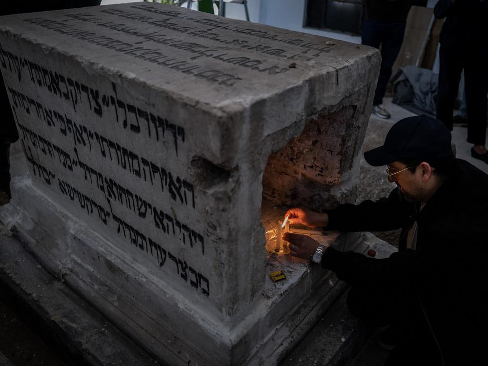 Cantor Henry Hamra lights a candle at the 400-year-old grave of Rabbi Hayyim ben Joseph Vital, a key figure in mystical Judaism.