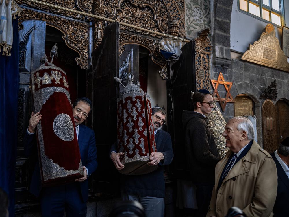 Members of the Jewish delegation, accompanied by former U.S. Ambassador-at-Large Stephen Rapp, carry an historic Torah in the Faranj synagogue in Damascus.