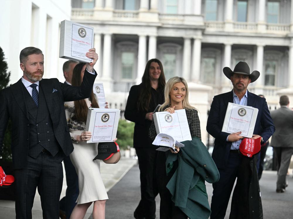 (From L) Political commentator Rogan O'Handley, aka DC Draino, TikToker Chaya Raichik, conservative activist Scott Presler, commentator Liz Wheeler and conservative political commentator Chad Prather carry binders containing Jeffrey Epstein files out of the White House on Thursday.